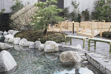 <p>บ่อน้ำพุร้อนด้านนอกที่ล้อมรอบด้วยสวนแบบญี่ปุ่น</p>